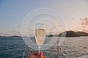 Bubby sparkling champagne flute glass with evening scene while sailing in the Pacific Ocean in Queensland Australia