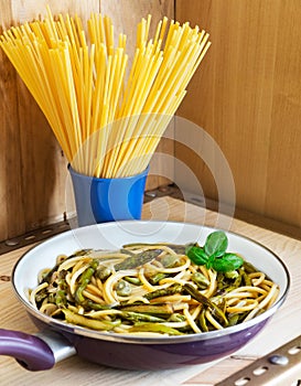 Bucatini with seasonal vegetables in a frying pan