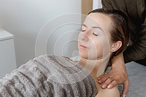 buccal facial and neck massage, close-up, cosmetologist makes woman a procedure on a massage table in a spa salon