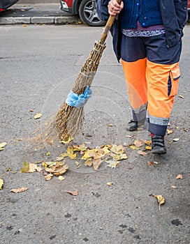 Bucharest/Romania - 11.08.2020: Street sweeper or garbage man broomig the leaves from the street or sidewalk