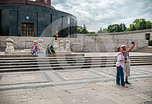 BUCHAREST, ROMANIA - MAY 14, 2017: Carol Park in Bucharest, Romania. Mausoleum in Background. Adults Taking Selfie.