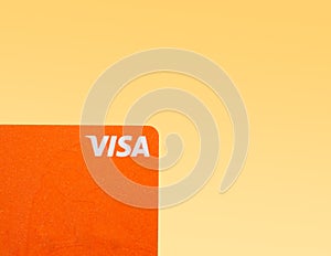 Orange Visa credit or debit card on gradient background. Online electronic commerce concept