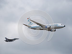 A Boeing 737-78J with Tarom Happy 66 years Livery flying at an airshow. Airplane escorted by a