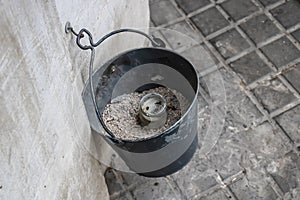 Bucket ashtray hanging on the building wall - Image