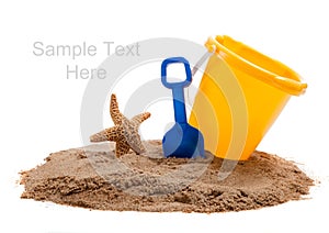 Bucket on beach with blue shovel and starfish