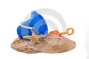 Bucket on a beach with a shovel and starfish