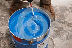 Bucket of blue paint mixing on motion