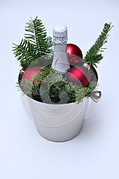 bucket with a bottle of champagne, fir branches and New Year\'s balls