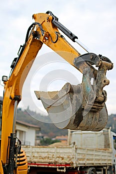 Bucket of a BULLDOZER and a truck in the background during the r