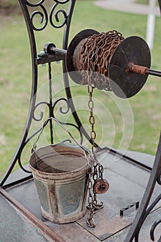 Bucket on a chain. Old well in a village. The old draw well.