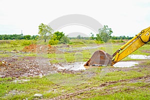 Bucket excavator in a muddy field with copy space