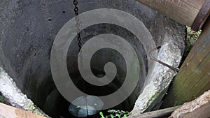 A bucket filled with water slowly rises from the well.