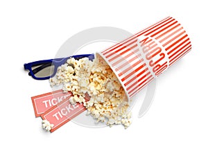 Bucket of fresh popcorn, tickets and 3D glasses on white, top view. Cinema snack