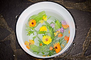 Bucket full of pure water and flowers