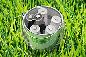 A bucket full of waste batteries. Environmental concept