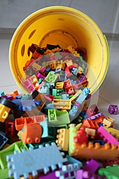 A bucket of Scattered Legos on the Floor