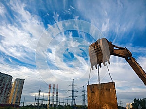 Bucket loader lifting metal panel with blue sky on background. Fisheye lens shot