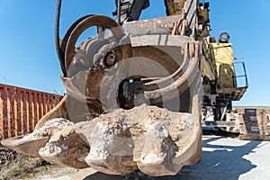 The bucket of an old quarry excavator is a close-up. The crawler excavator is located on the territory of a mining quarry. an open
