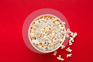 Bucket of popcorn on red background, top view