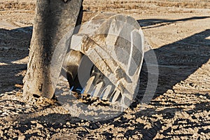 The bucket of a powerful excavator against the background of the evening sky. Construction machinery for earthworks