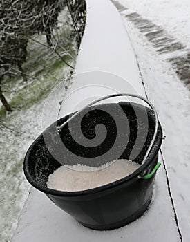 Bucket with salt used to melt ice and snow