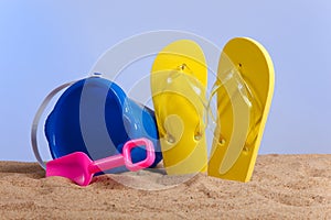 Bucket, shovel and flipflops on the beach