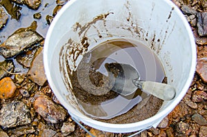 Bucket and shovel with mineral rich material for gold panning.