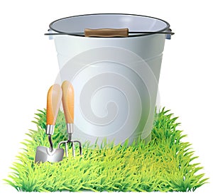 Bucket, shovel, rake on a green grass