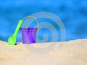 Bucket and shovel in sand on seashore