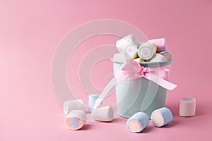 Bucket with sweet candy marshmallows  on pink pastel background.