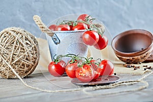 Bucket of tomatoes and half cut tomato on wooden table