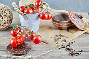 Bucket of tomatoes and half cut tomato on wooden table