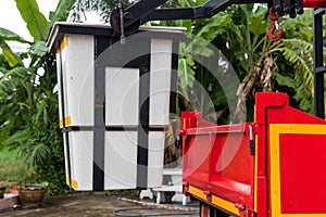 Bucket truck of a crane. Red truck with white picker crane parked on the side of the road