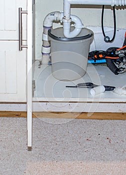 Bucket under a pipe of a leaking sink