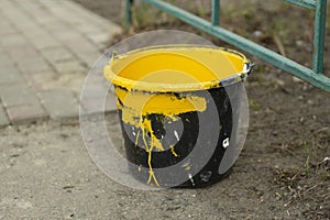 A bucket of yellow paint. Paint for painting parking posts