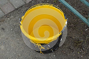 A bucket of yellow paint. Paint for painting parking posts