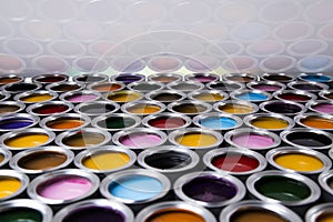 Buckets full of rainbow colored oil paint