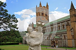 Buckfast Abbey in Dartmoor with a statue of Mary and Baby Jesus in the foreground