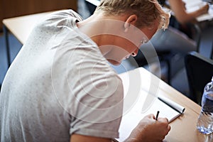 Buckling down for long hard examination. a young college student studying in class.