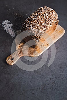 Buckwheat bread with multi seeds on wooden table. Vertival picture. Blogging concept