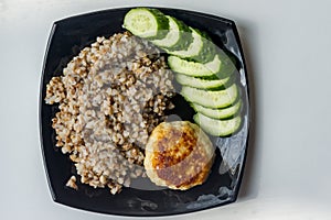 Buckwheat cereal with grilled chicken cutlet and slised cucumber