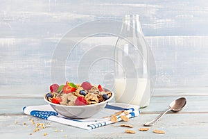 Buckwheat flakes with berries in bowl and jar of milk