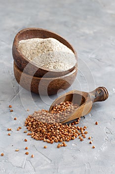 Buckwheat flour in a bowl and buckwheat grain with a spoon