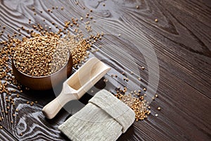 Buckwheat groats (hulled seeds) on brown wooden background photo