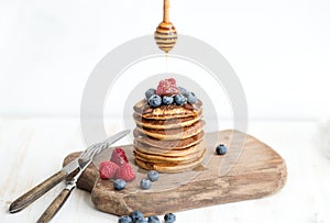 Buckwheat pancakes with fresh berries and honey on