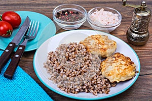 Buckwheat porridge with cutlets on white plate