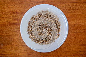 Buckwheat porridge in white plate. Healthy food..