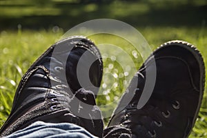 Bucolic black urban trainers over green grass background