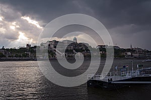 Budapest castle illuminated by the sunbeams under a stormy sky, Hungary