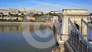 Budapest, Hungary - 4K flying above Szechenyi Chain Bridge with busy morning traffic at sunrise. Fisherman`s Bastion at background